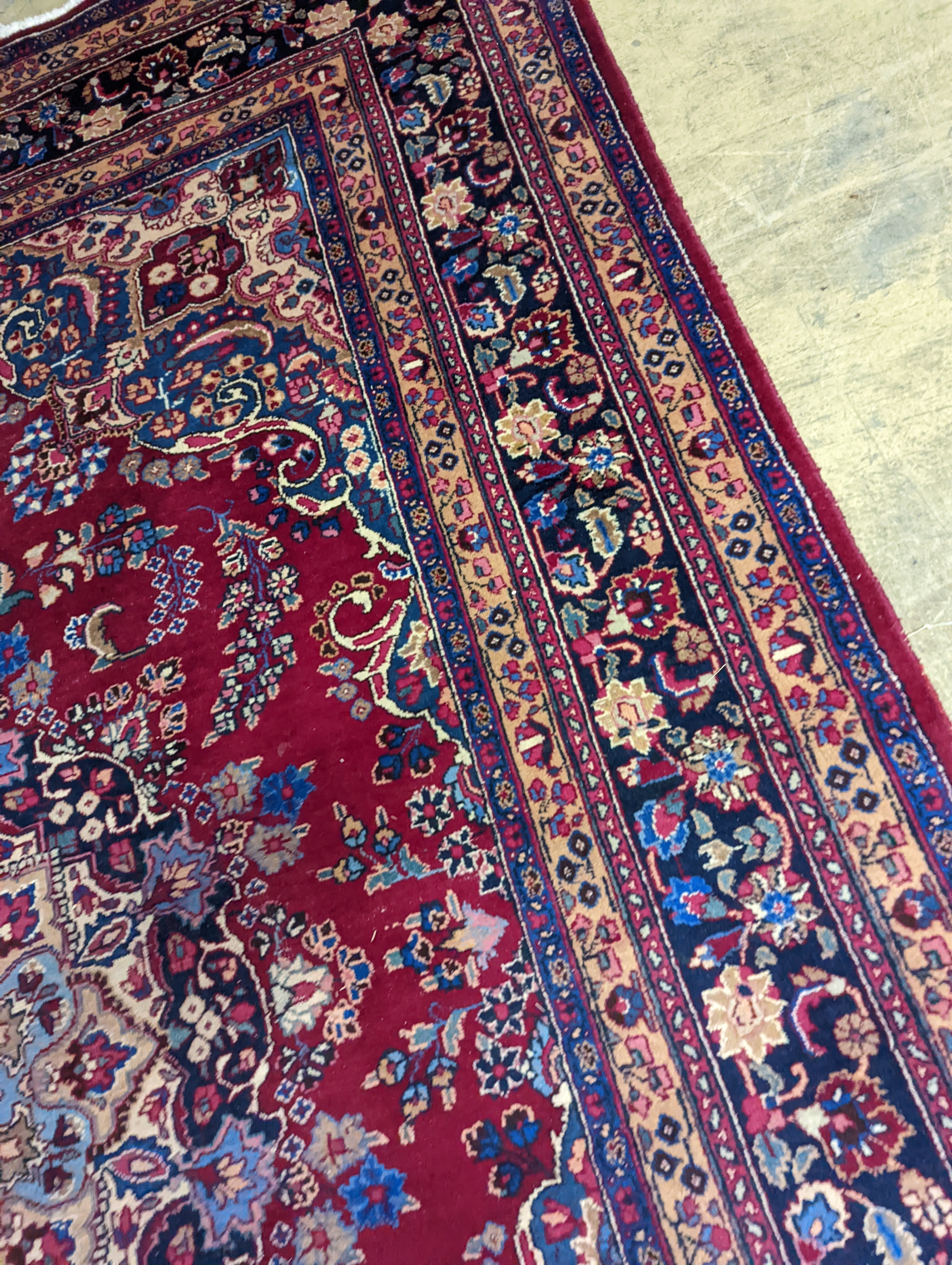 A Tabriz burgundy ground carpet, 350 x 250cm